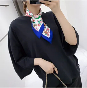 Close-up of floral silk scarf styled as a bow tie with butterfly and dragonfly patterns