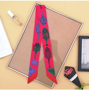 Detailweergave van fuchsia zijden sjaal met vintage lantaarnpatronen voor handtassen