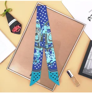 Close-up of royal blue twilly scarf with heart and equestrian print on a styled display