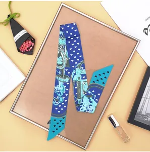 Detailed view of blue silk twilly with vintage horse prints and heart patterns