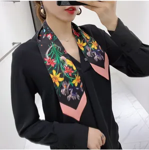 Detail of floral silk scarf styled with black v-neck shirt for a chic feminine look