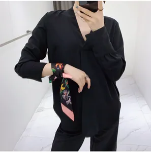 Close-up of floral print silk scarf ribbon styled as a wrist accessory with black shirt