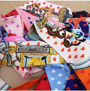 Detailed view of 100% silk twill scarves featuring heart and equestrian buckle patterns
