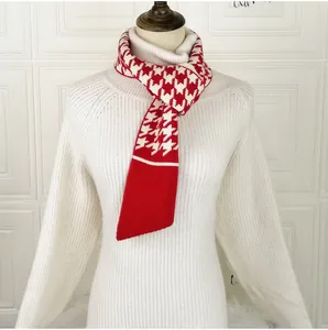 Detail of red and white houndstooth knit scarf featuring elegant button decoration