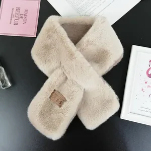 Close-up of soft khaki faux fur scarf with a premium leather brand tag on black surface
