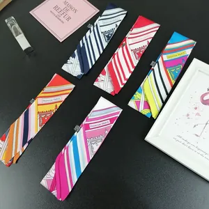Flat lay of stylish silk twilly scarves with dot patterns and Fashion Paris lettering