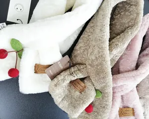 Dettaglio di sciarpe di peluche con decorazioni a ciliegia 3D e design a incrocio