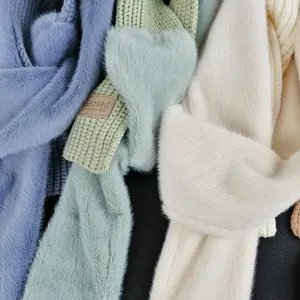 Close-up of knit and faux fur patchwork scarf in pastel blue, green, and cream colors