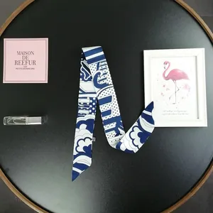 Dettaglio della sciarpa stretta Twilly in seta con stampe geometriche blu navy