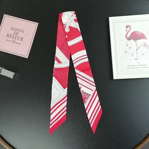 Close-up of red and white polka dot silk twilly scarf with elegant architectural patterns