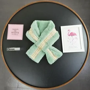 Close-up of mint green faux fur scarf featuring a decorative tweed ribbon detail
