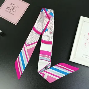 Close-up of a twilly scarf with geometric stripes, horse harness patterns and a care label