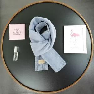 Detail of light blue faux fur scarf with knitted ribbing and brown leather Beloved label
