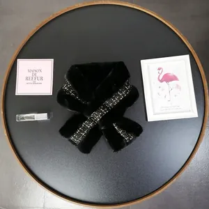 Close-up of black faux fur scarf featuring elegant black and gold tweed detail on tray