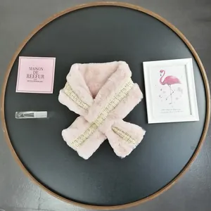 Detail of pink faux fur scarf with gold metallic woven trim and soft plush texture