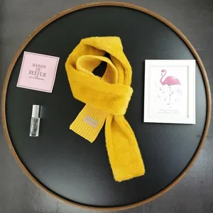 Close-up of ginger yellow knit scarf with faux rabbit fur and Beloved leather label