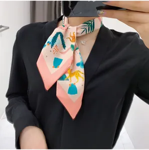 Pink silk floral scarf with leopard print tied as a necktie on a black V-neck top