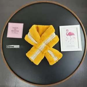 Detail of yellow faux fur scarf with weave ribbon and crossed loop fastener design