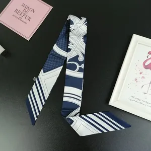 Detail view of navy and white polka dot silk scarf with twill texture and laundry label