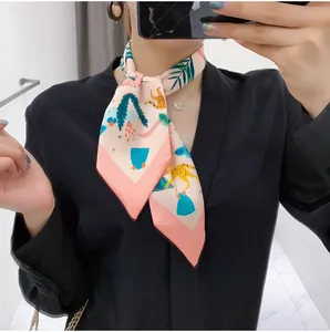 Detail of pink floral silk scarf with leopard print and green tropical leaf patterns