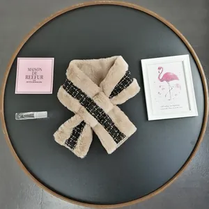 Detail of beige faux fur scarf with black gold tweed patchwork and crossover design