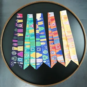 Set of colorful skinny silk scarves with luxury horse bridle patterns in a round tray