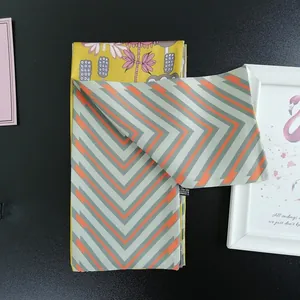 Detail of printed polyester scarves showing floral patterns and orange chevron textures