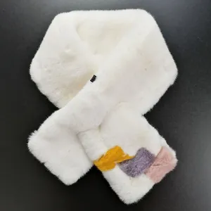 Macro detail of white faux fur scarf with vibrant yellow and pink patchwork accents