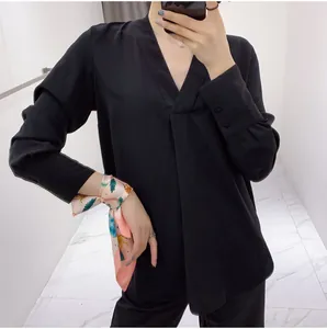 Detail showing high-quality silk scarf tied to wrist paired with chic V-neck shirt set