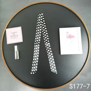 Detailed flat lay of black silk twilly with white heart pattern and fashion decor