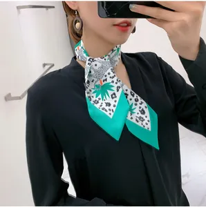Detail of floral and leopard print narrow silk scarf with mint green edges worn by model