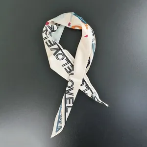 Detail of skinny silk scarf featuring LOVE lettering and colorful cartoon print design
