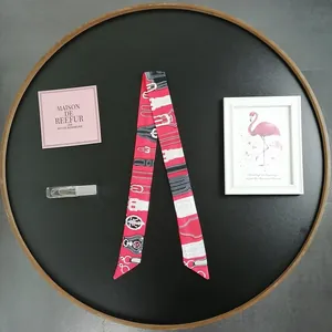 Vertical view of red Twilly scarf with equestrian horse bit pattern and belt motifs