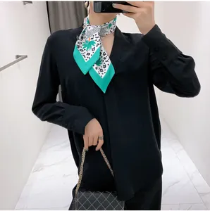 Floral and leopard print silk scarf styled as a necktie with black shirt and chain bag