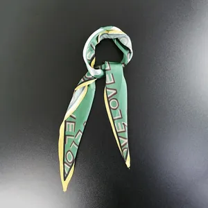 Close-up of forest green Twilly silk scarf with yellow edges and LOVE letter print