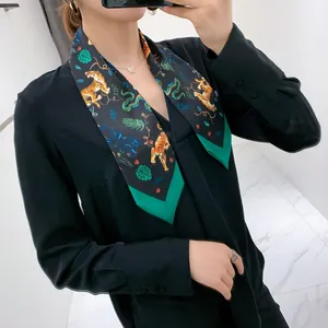 Detail of tiger and floral print silk scarf featuring elegant pointed ends and green edging