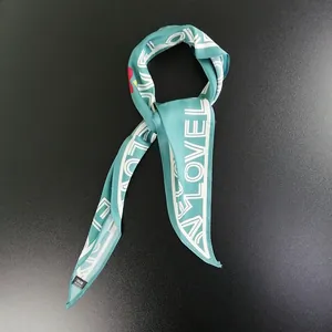 Detailed view of teal satin neck scarf with white LOVE lettering and soft silk texture