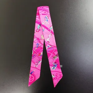 Dettaglio del twilly in seta rosa con stampe artistiche e trama del tessuto raffinato
