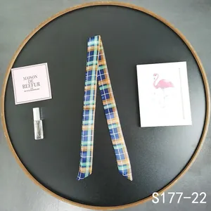 Classic plaid twilly scarf in navy and orange styled on a decorative black tray