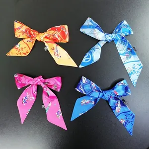 Dettaglio di quattro foulard di seta stampati colorati annodati a fiocco su fondo nero