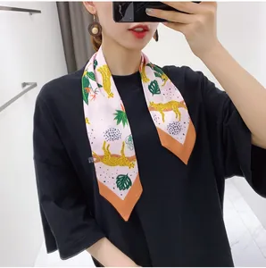 Detail of floral silk scarf tied on neck showing leopard and tropical leaf print