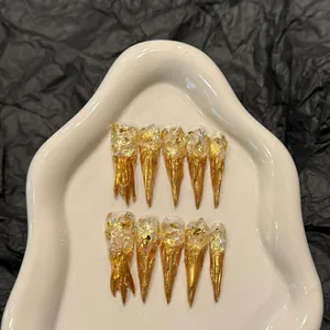 Luxurious gold foil stiletto press-on nails with shimmering fluid art and translucent finish