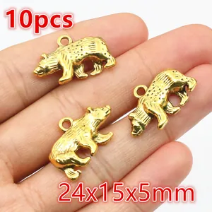 Detailansicht von 10 goldenen Bären-Anhängern aus Legierung mit Größe 24x15x5mm auf Hand