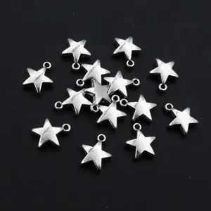 Silver alloy star pendants for DIY jewelry making scattered on dark background