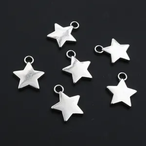 Close-up of six silver star pendants for DIY jewelry making on a dark matte surface