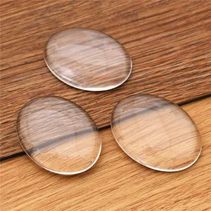 Trois cabochons ovales en verre transparent sur fond de bois pour bijoux artisanaux