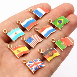 Macro view of ten assorted national flag alloy charms held in hand for size display