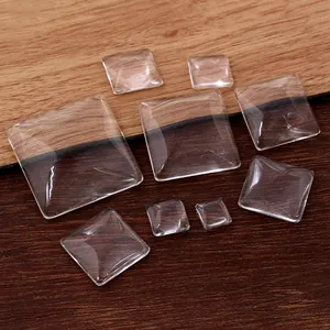 Cabujones de vidrio cuadrados en varios tamaños para joyería DIY sobre fondo madera