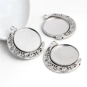 Close-up of three rotating 25mm silver alloy pendant trays with carved patterns for DIY jewelry