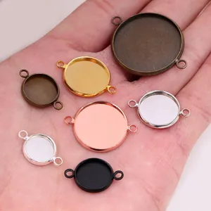 DIY round metal tray pendants in gold, silver and bronze held in palm for size reference